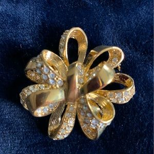 Classic tied-ribbon shaped brooch covered in rhinestones.